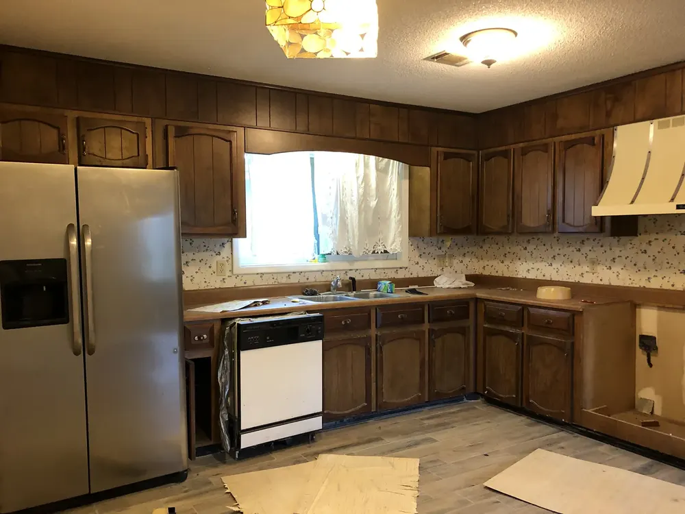 An outdated kitchen with missing appliances in a Warner Robins home