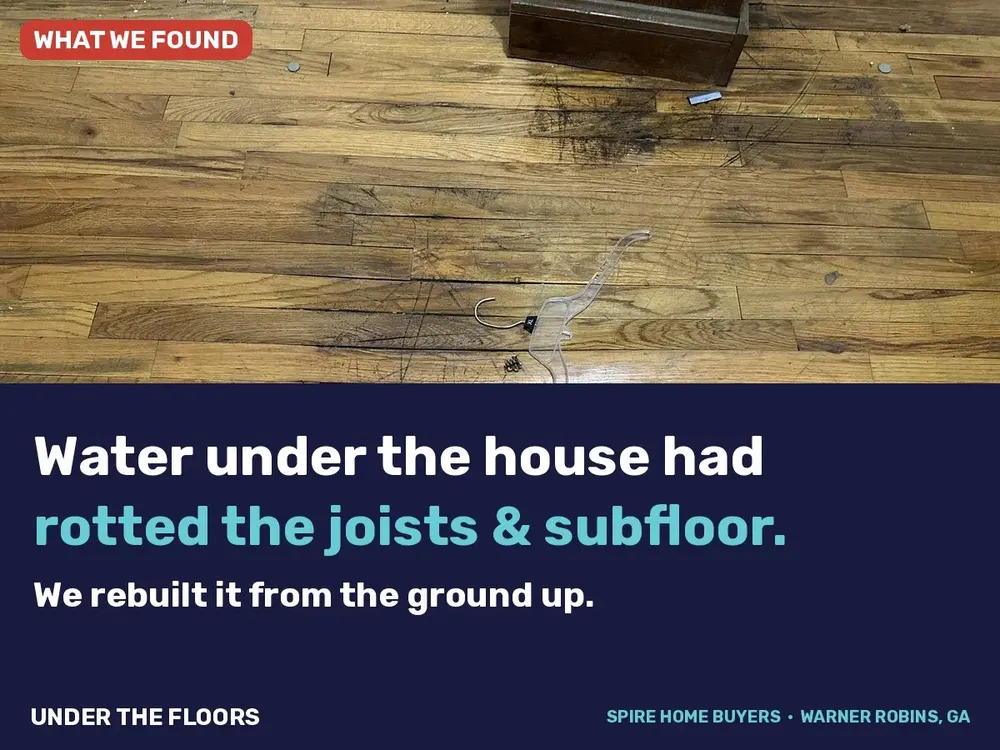 Water-stained, damaged hardwood floor at 338 Mike St in Warner Robins before renovation
